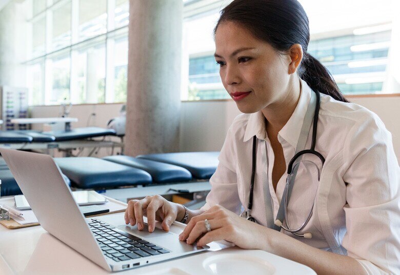 female doctor working on her laptop in therapy room