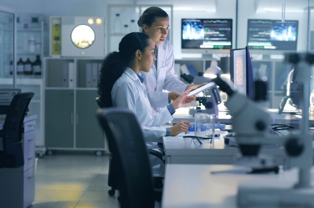 Two doctors reviewing computer in a clinical laboratory.
