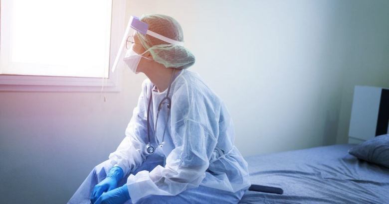 female doctor in protective gear taking a break in a hospital