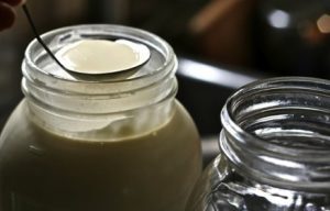 ladle scooping cream from mason jar