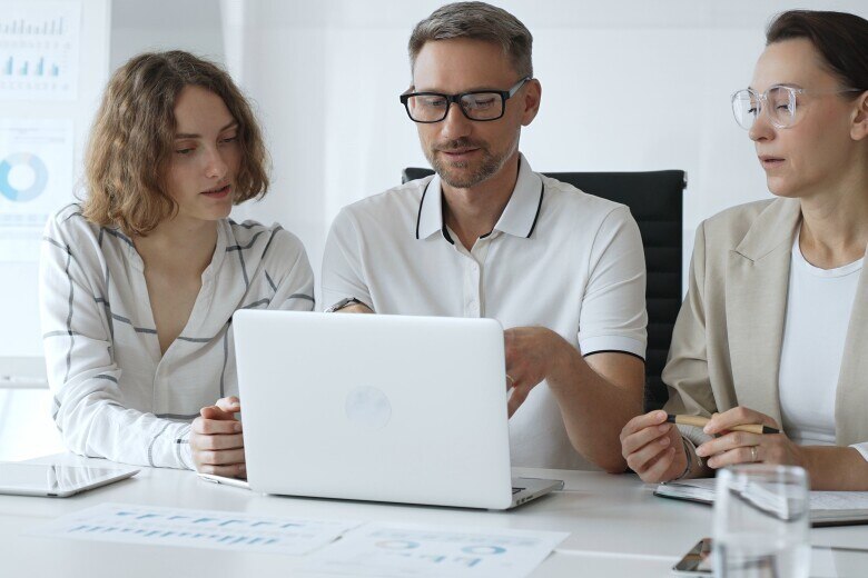Professional Team Analyzing Data on Laptop in a business meeting