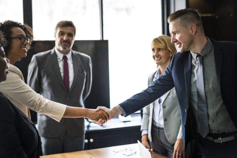 people in a conference room shaking hands