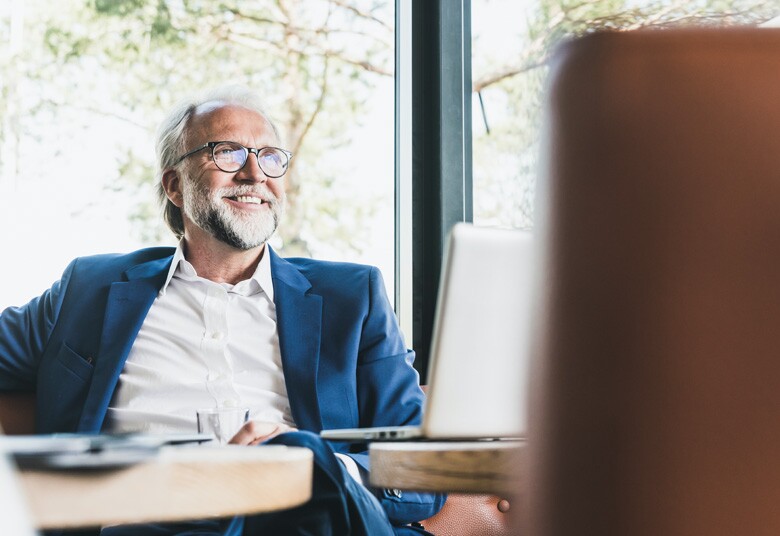 man sitting at desk smiling