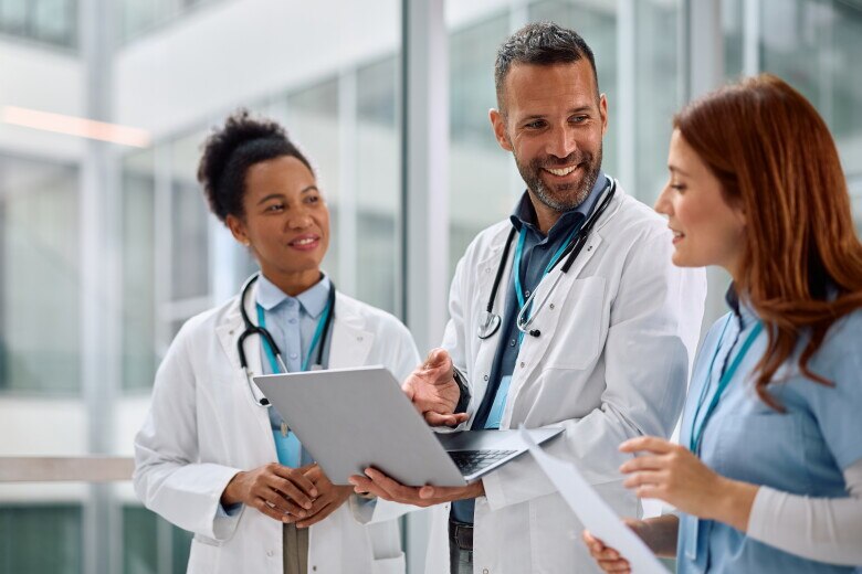 Team of medical experts cooperating while working on laptop at the hospital.