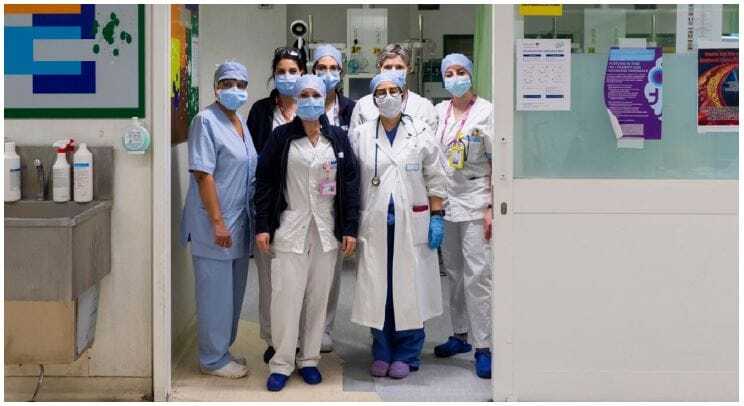 group of doctors in a doorway at a hospital wearing masks