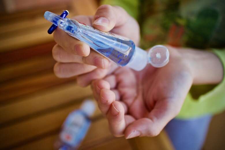 person squeezing hand sanitizer on their hands