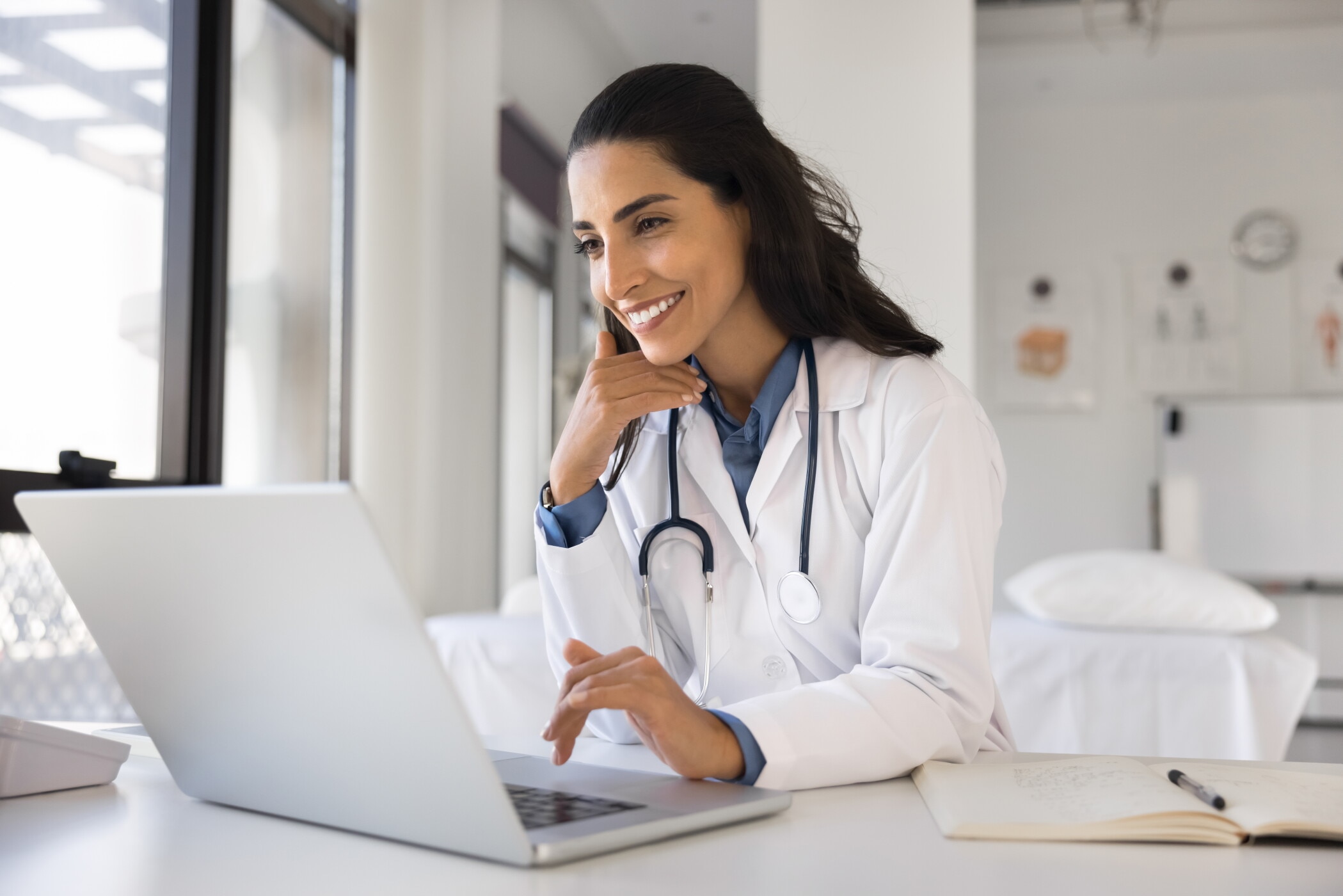 Doctor at desk using modern laptop