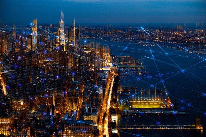 City skyline at night with lights representing a communication network