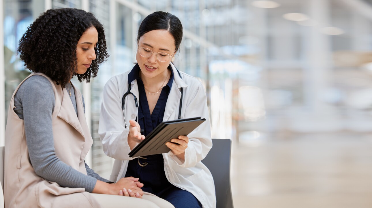 Doctor holding tablet, consulting with female patient on results, medical info and healthcare