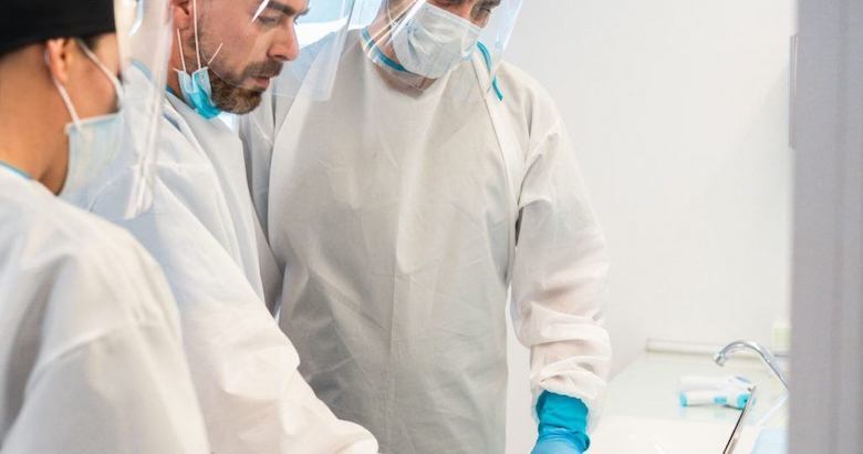 doctors wearing personal protective equipment while discussing a patient