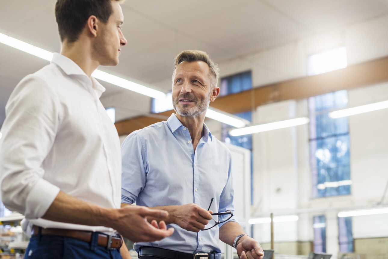 Two businessmen having a discussion in factory