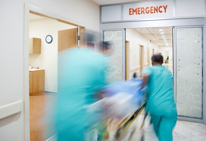 emergency room doctors rushing a patient through sliding doors