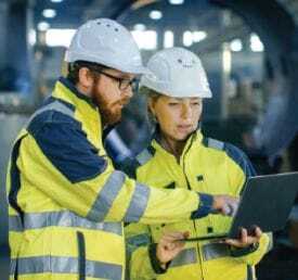 engineers on work site looking at laptop