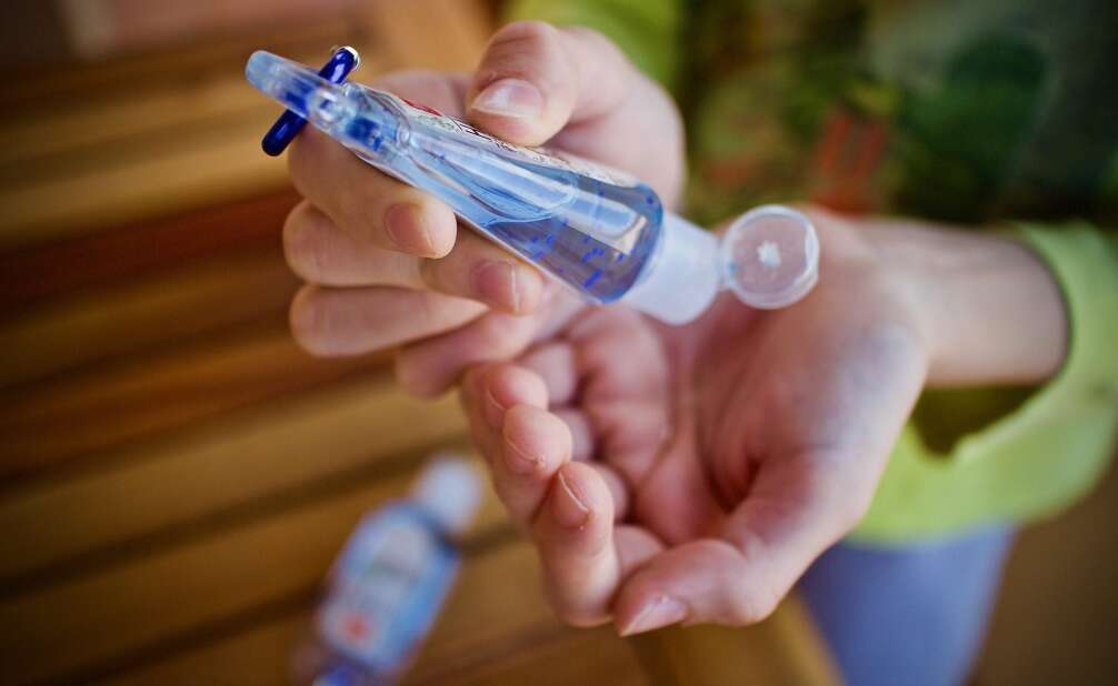woman applying hand sanitizer to her hands during COVID-19 pandemic